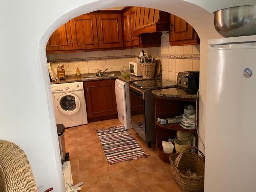 a kitchen with a sink and a washing machine at Casa da Praça - Mourão in Mourão