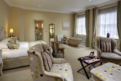 a bedroom with a bed and a bathroom with a tub at Best Western Plus Sheffield Mosborough Hall Hotel in Sheffield