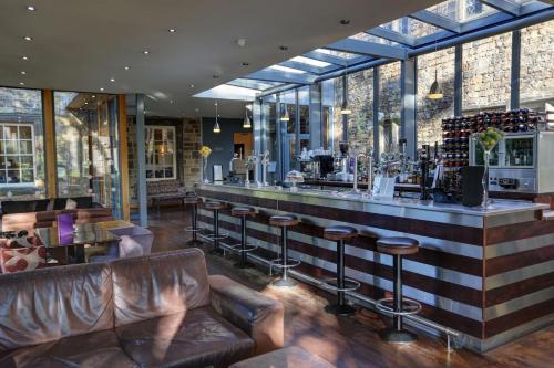 a bar in a restaurant with leather furniture at Best Western Plus Sheffield Mosborough Hall Hotel in Sheffield