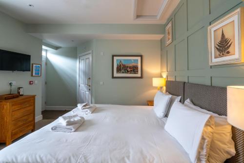 a bedroom with a large white bed and a television at The Kings Arms Hotel in Melksham