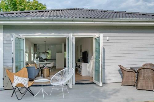 eine Erweiterung zu einem Haus mit Stühlen und einer Terrasse in der Unterkunft Das Norwegerhaus Ostsee in Graal-Müritz