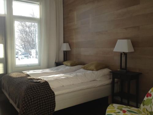 um quarto com uma cama com 2 candeeiros e uma janela em Sentrumsgården Motell AS em Presteid