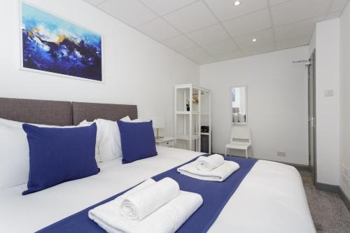 ein Schlafzimmer mit einem großen Bett mit blauen und weißen Kissen in der Unterkunft Sovereign Gate - 2 bedroom apartment in Portsmouth City Centre in Portsmouth