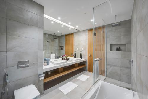 a bathroom with two sinks and a shower at bnbmehomes - Best views in Dubai- 1 JBR Penthouse - 3703 in Dubai