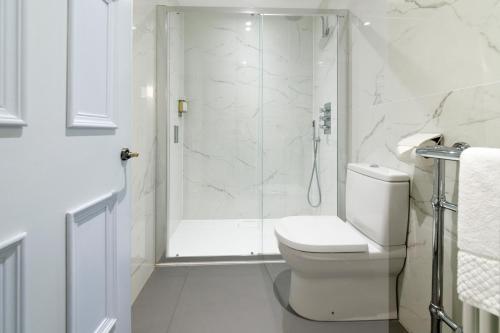 a white bathroom with a shower and a toilet at Lews Castle in Stornoway
