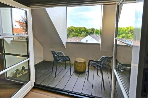 a balcony with three chairs and a table at Hotel Abdijhof Thorn in Thorn