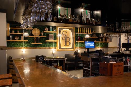 Un bar con un gran mostrador de madera en una habitación. en Graduate by Hilton Lincoln, en Lincoln