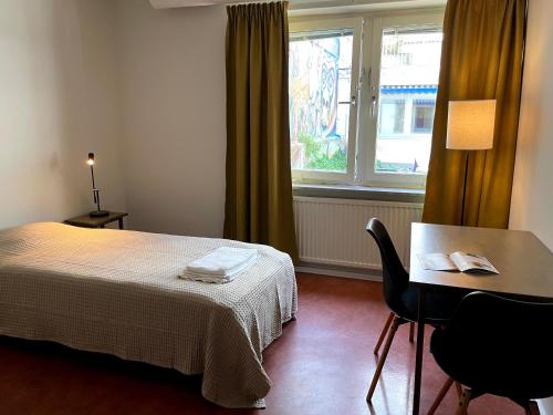 Zimmer mit einem Bett, einem Tisch und einem Fenster in der Unterkunft HOTEL N Hostel Malmö City in Malmö