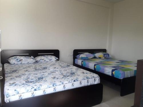 two beds in a room with two beds at Machan Villas by Holiday Club in Bhor