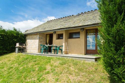 a house with a table and chairs in the yard at Village de gîtes de Sainte-Lucie in Sainte-Lucie