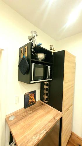 a kitchen with a microwave and a wooden table at FRANKES CITY SLEEP Apartment, 6 Einzelbetten in Velbert
