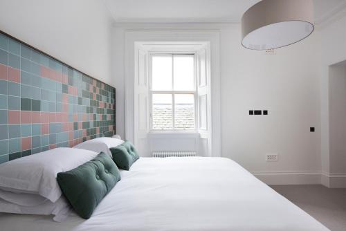 a bedroom with a large white bed and a window at Lews Castle in Stornoway