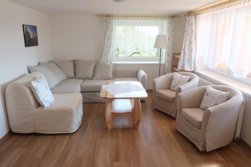 a living room with a couch and two chairs and a table at Apartmány U Zvoničky in Prachov