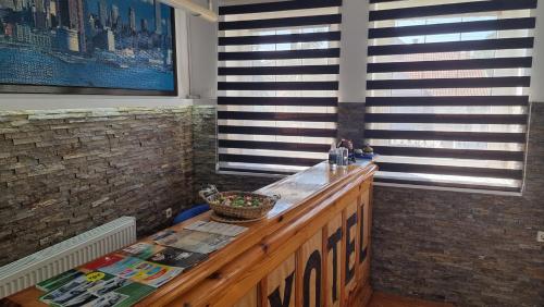 a counter in a room with two windows with blinds at Guest House Luxotel in Zrenjanin