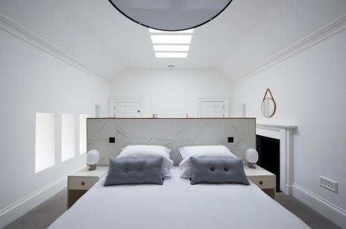 a white bedroom with a large bed with two pillows at Lews Castle in Stornoway