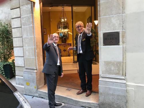two men in suits standing in front of a building at Hôtel Delavigne in Paris