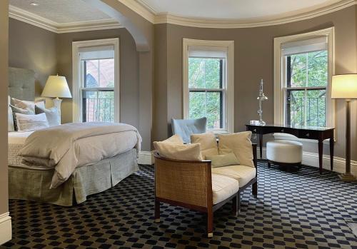 1 dormitorio con cama, silla y piano en Clarendon Square en Boston