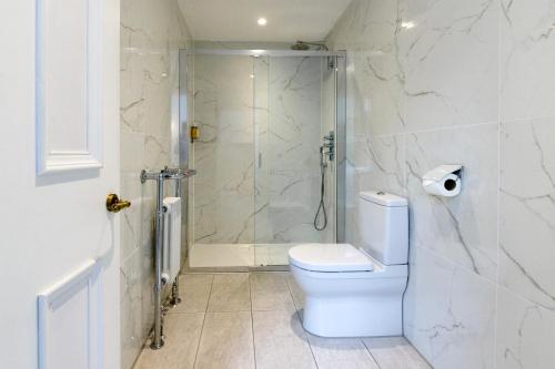 a white bathroom with a shower and a toilet at Lews Castle in Stornoway