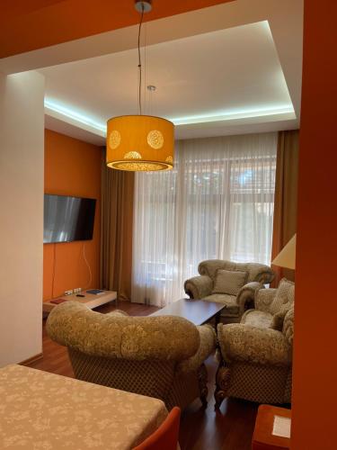 a living room with a couch and chairs and a table at Arcada Apartments in Odesa