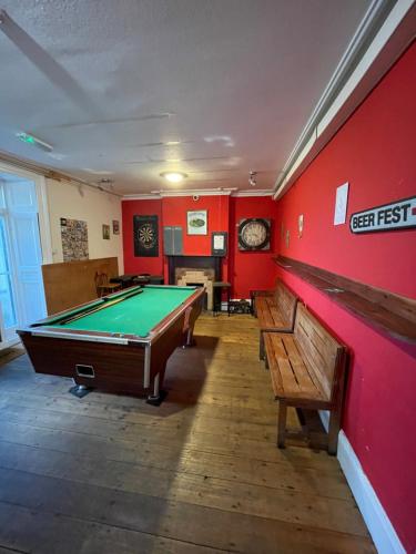 a green room with a wooden floor and a red wall at Y Pengwern in Ffestiniog
