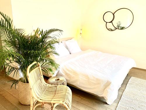 - une chambre avec un lit, une chaise et des plantes dans l'établissement Rooms & Loft De Post, à Gavere
