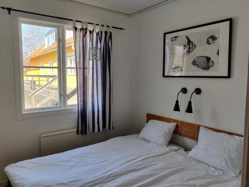 a bedroom with a white bed and a window at Ronneby Havscamping in Listerby