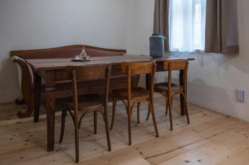 a dining room table with chairs and a wooden table at Tschardakenhof Appartements in Lutzmannsburg
