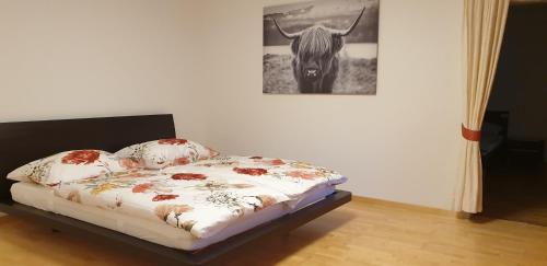 Cama en habitación con foto de vaca en Ferienwohnung Heidi en Absam