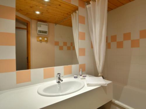 une salle de bain avec un lavabo et un miroir dans l'établissement travelski home classic - Vue Pistes, à Aime La Plagne