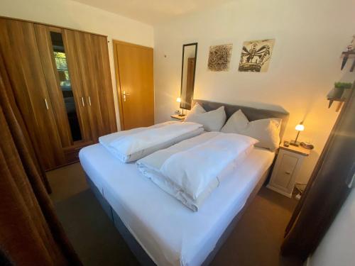 ein Schlafzimmer mit einem großen weißen Bett mit weißen Kissen in der Unterkunft Kitz Residenz Appartement 10 Kaprun in Kaprun