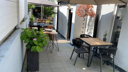 an outdoor patio with tables and chairs and a plant at Boutique Hotel Villa Sarah in Düsseldorf
