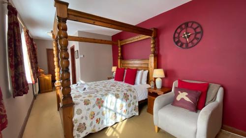 a bedroom with a bed and a chair and a clock at The New Inn in Pickering