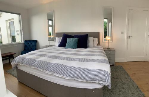 a bedroom with a large bed with blue pillows at Zepher Apartment in Doolin