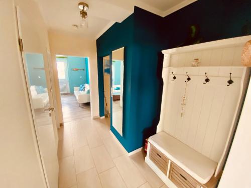 a bathroom with a blue wall and a white cabinet at COAST HOUSE Dünenloft in Bremerhaven