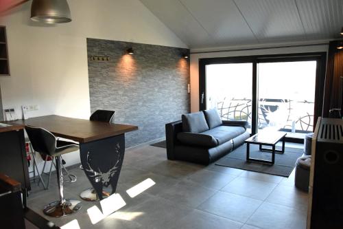 een woonkamer met een bank en een tafel bij Le Cerf1 in Bertogne