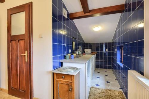 卡洛夫的住宿－Chata Kataryniarza，浴室设有蓝色瓷砖墙壁和水槽
