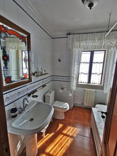 a bathroom with a sink and a toilet and a mirror at Casa de Cacheiro - Silleda in Silleda