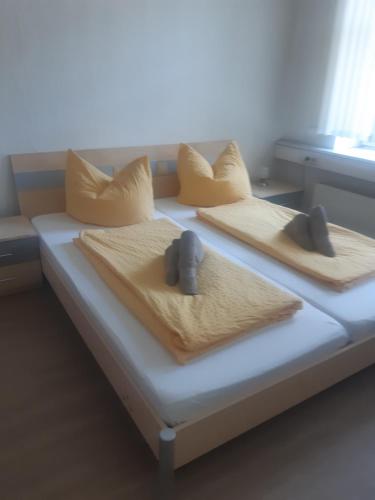 a bed with three pillows on top of it at Pension Savo in Chemnitz