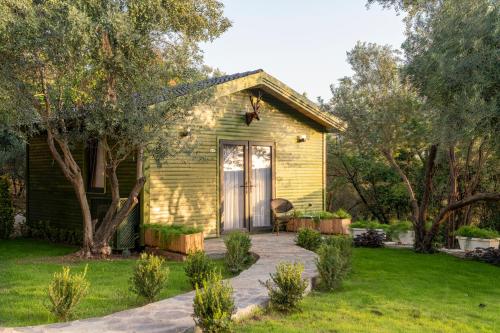 a small yellow house with a patio in a yard at APA Mountain Lodge in Antalya
