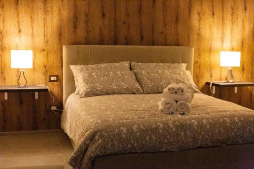 a stuffed animal sitting on a bed with two lamps at Mamì B&B in Naples