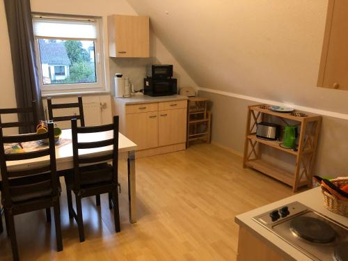 eine Küche mit einem Tisch und Stühlen im Zimmer in der Unterkunft Ferienhaus Zur Heide - Obergeschoss in Radibor