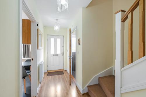 a hallway with white walls and a white door at London Heathrow Living Holywell Serviced Houses - 3 and 4 bedrooms By Ferndale in Stanwell