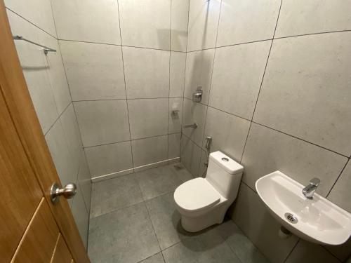 a small bathroom with a toilet and a sink at KARIPPALS INN in Kottayam