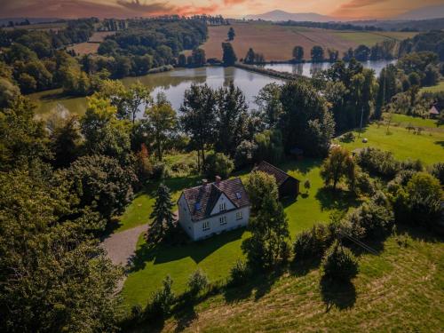 an aerial view of a house on a hill with a lake at Nasz Dębowiec - dom dla 15 osób, sauna, widok na staw, wielka działka in Dębowiec