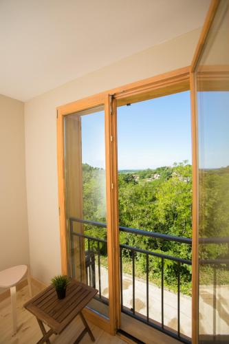 a room with a large window with a table and a balcony at Illaberek Vendégház in Sukoró