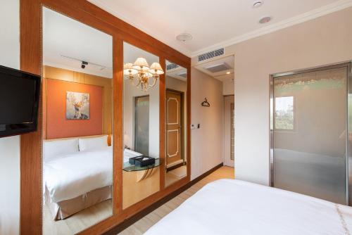 a hotel room with two beds and a tv at 二川行旅 - HiRiver Hotel in Taichung