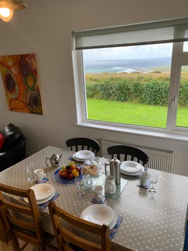 a table with chairs and a table and a window at Doolin View Apartment in Doolin