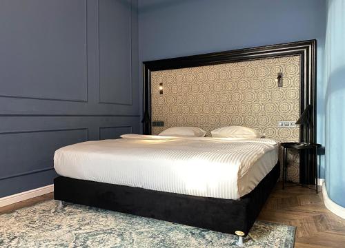 a bedroom with a large bed with a large headboard at Hotel Rumor in Budapest