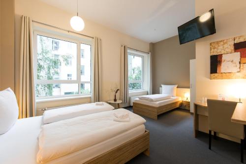 ベルリンにあるNu Wave Hotel Berlin - Digital Check-In 2025のベッド2台と机と窓があるホテルの部屋