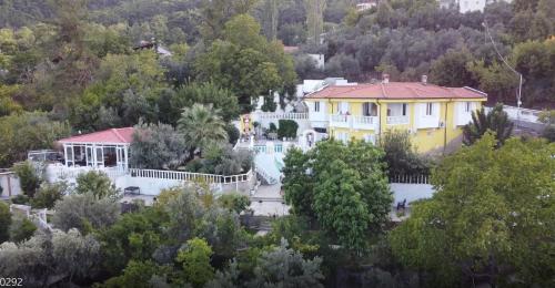 a large yellow house in the middle of a forest at APA Mountain Lodge in Antalya